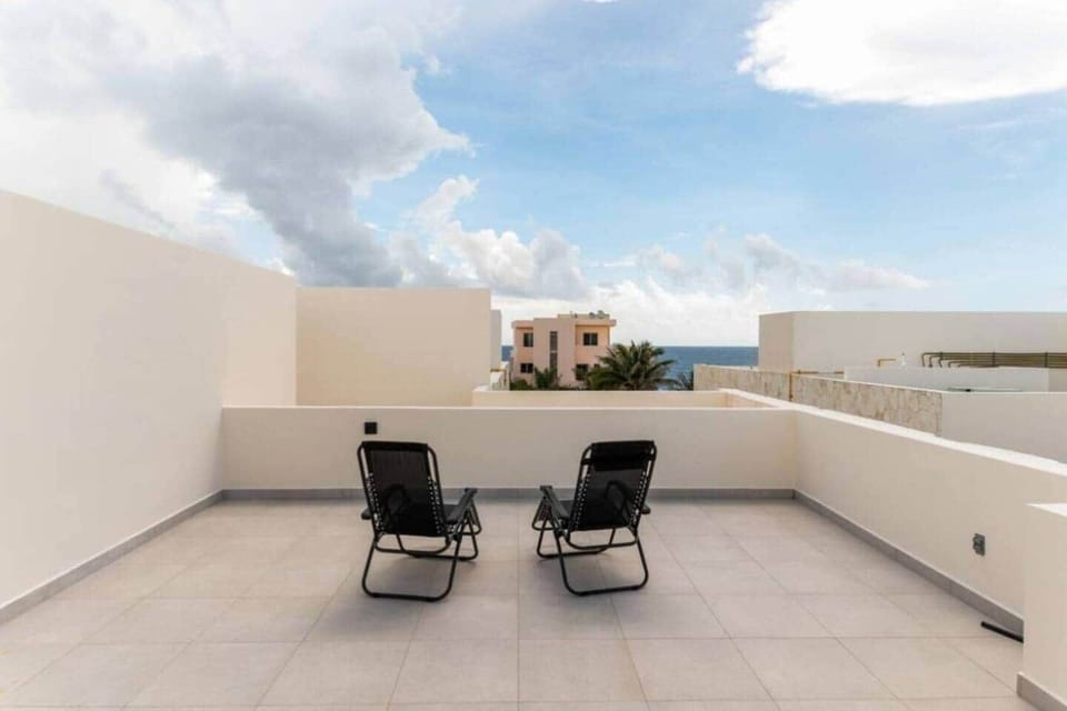 The private rooftop terrace features two reclining lounge chairs and Caribbean Sea views, creating the perfect spot to relax, sunbathe, or unwind while taking in the ocean breeze and open sky.