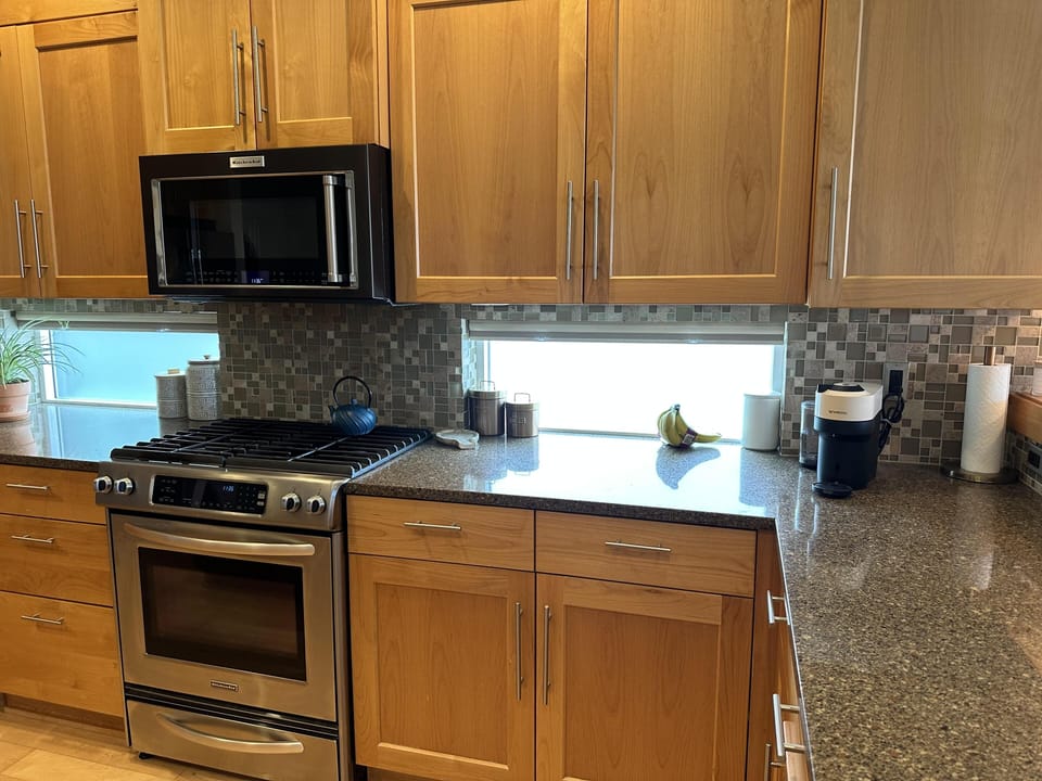 The modern kitchen features quartz countertops and stainless steel appliances