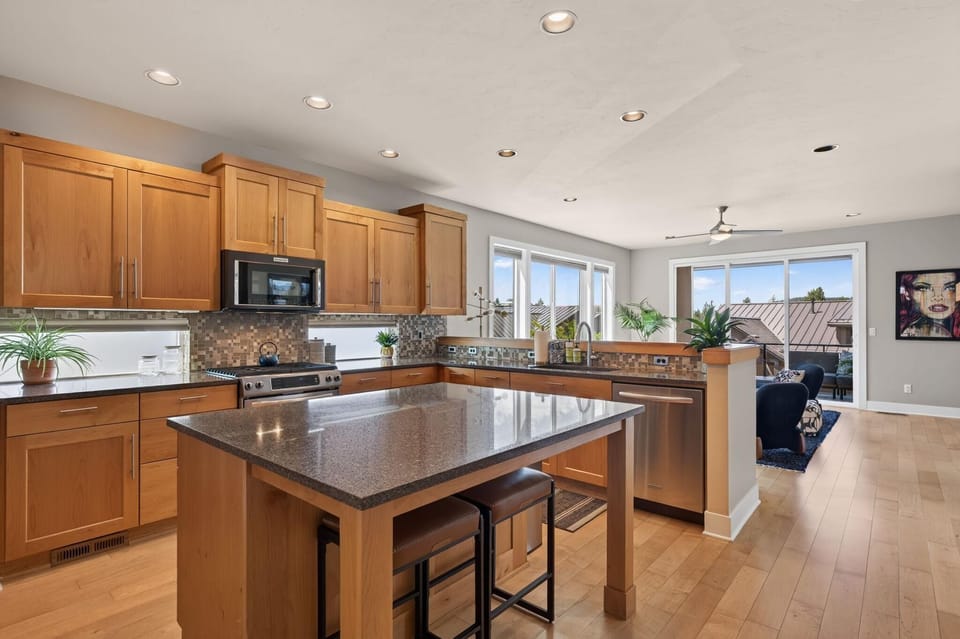 Lovely, modern and open kitchen with quartz counters with modern appliances and breakfast bar