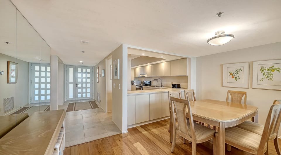 Bright dining area with open kitchen and hardwood floors