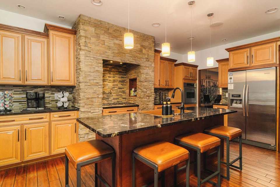 Fully equipped kitchen with island seating, modern appliances, and ample prep space for large groups.