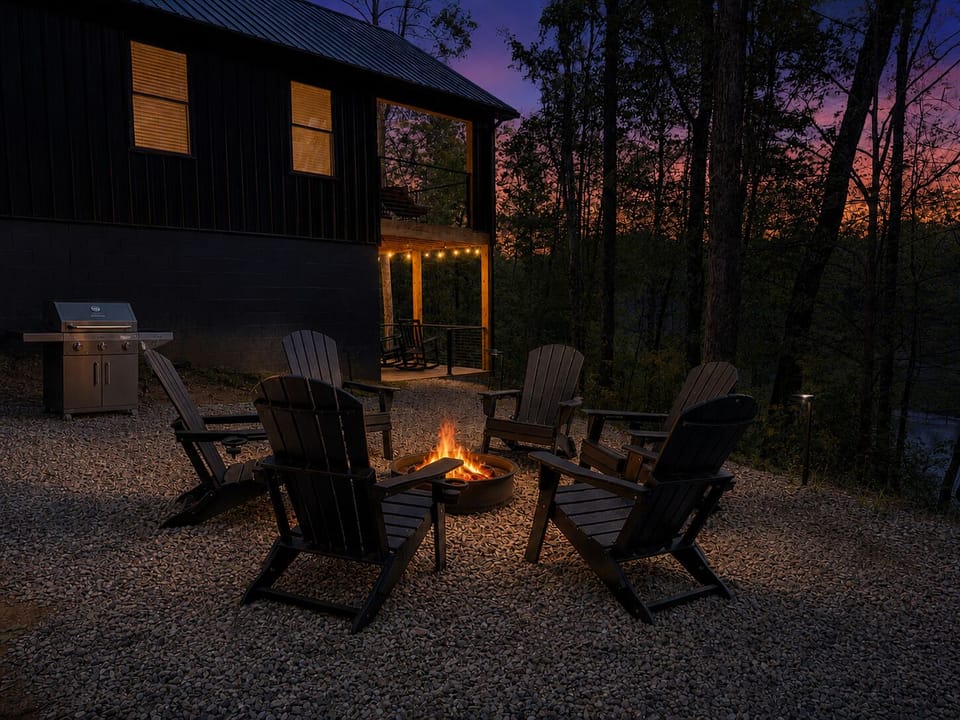 Fire pit area at Sherwood at night — Adirondack seating, woodburning fire pit glowing, firewood stocked and ready on arrival
