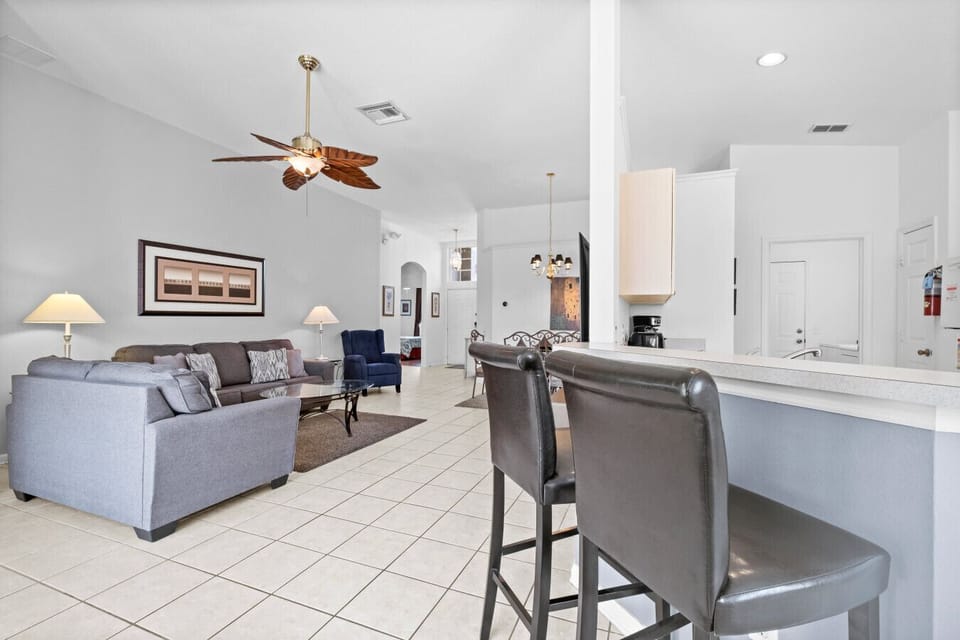 Open living area viewed from the kitchen with bar seating and pool access