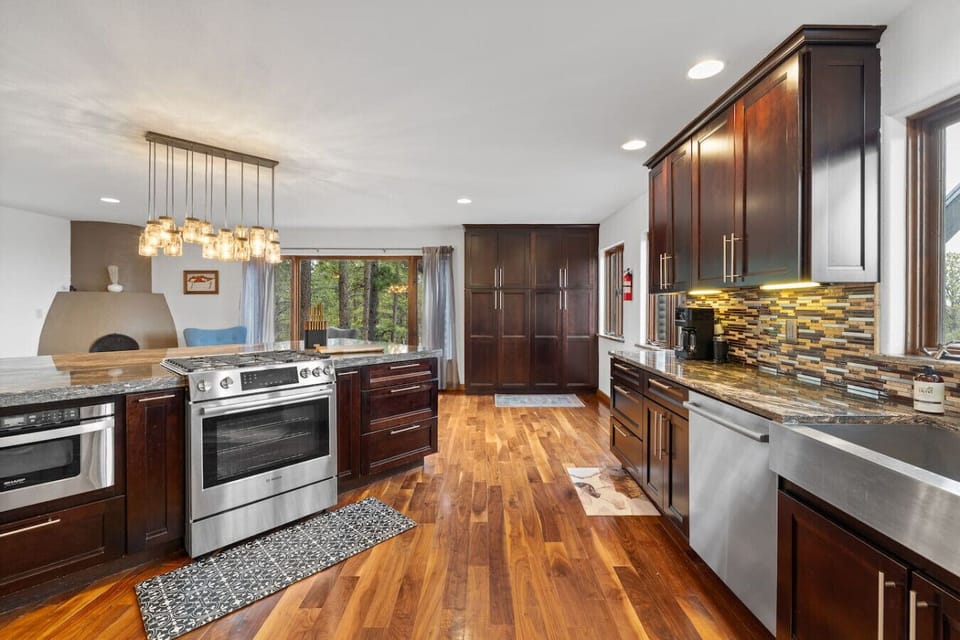 The heart of the home features top-of-the-line stainless steel appliances and rich, dark wood cabinetry contrasted by gleaming hardwood floors. This fully-equipped space provides everything needed for a seamless culinary experience.