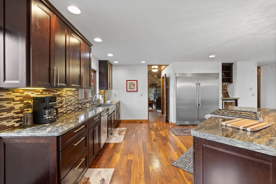 A chef`s delight with a professional-grade gas range, sleek stainless steel ventilation hood, and elegant granite countertops with a contemporary tile backsplash. Prepare your favorite meals in style and comfort.