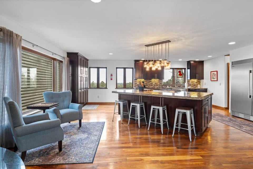 Retreat to this tranquil and comfortable sitting, featuring two plush accent chairs and large windows that frame beautiful outdoor views, creating a perfect space for reading or quiet conversation.