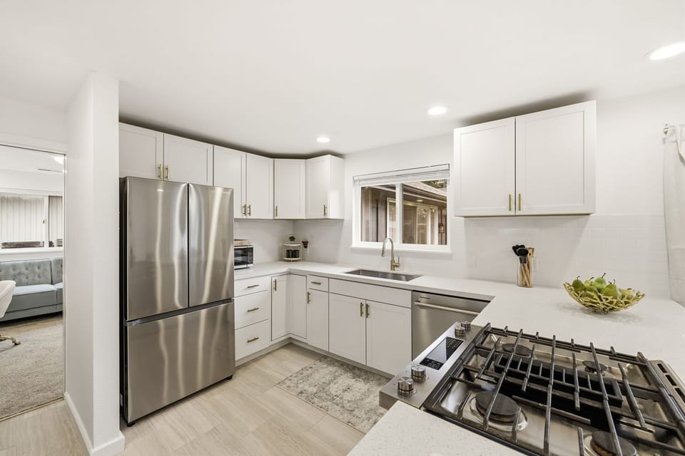 New kitchen with gas cooking, white quartz counters, 