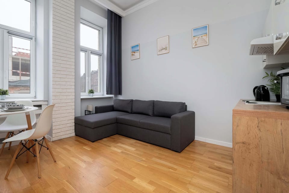 The living area with a soft sofa and light wooden floor feels open and airy, making it ideal for both relaxation and spending time together.