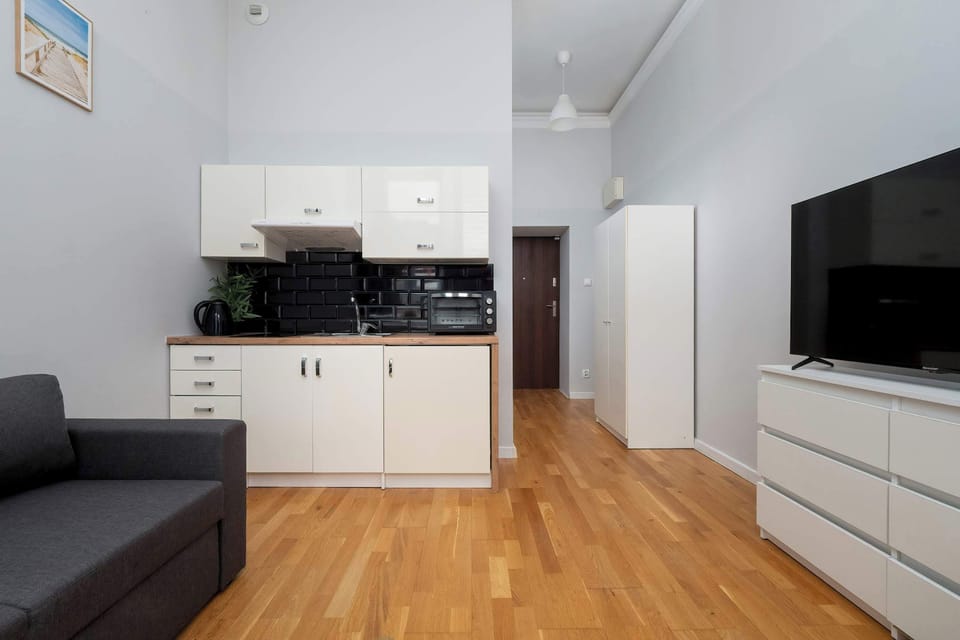 The open-plan living space with a sofa, TV, and kitchenette makes it easy to relax or plan the day ahead in one comfortable area.