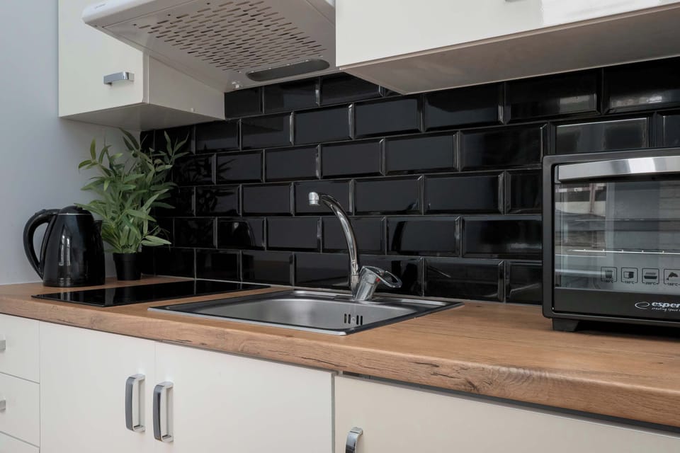 The functional kitchenette with a wooden countertop and modern finishes makes it easy to prepare meals and enjoy full independence, even during a short stay.