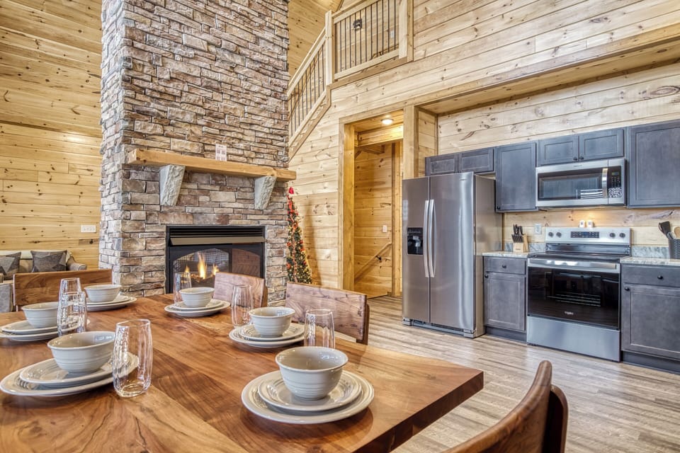Cabin with a Mountain View in the Smoky Mountains "View to a Thrill" - Dining area, fully furnished kitchen, and double sided stone encased gas fireplace