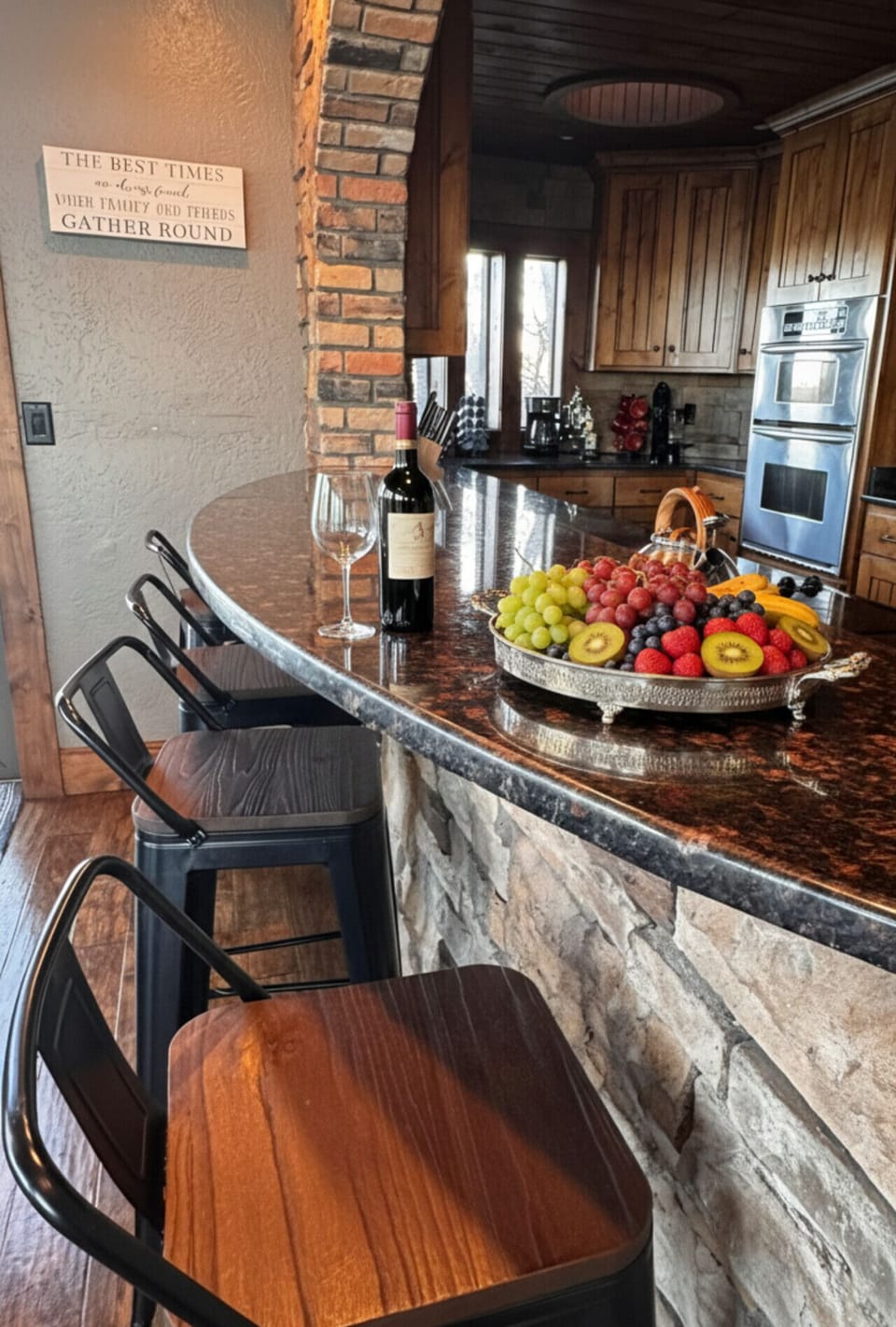 Rustic gourmet kitchen bar with granite countertops, stone accents, bar seating, and modern appliances — perfect for entertaining and relaxing cabin getaways.
