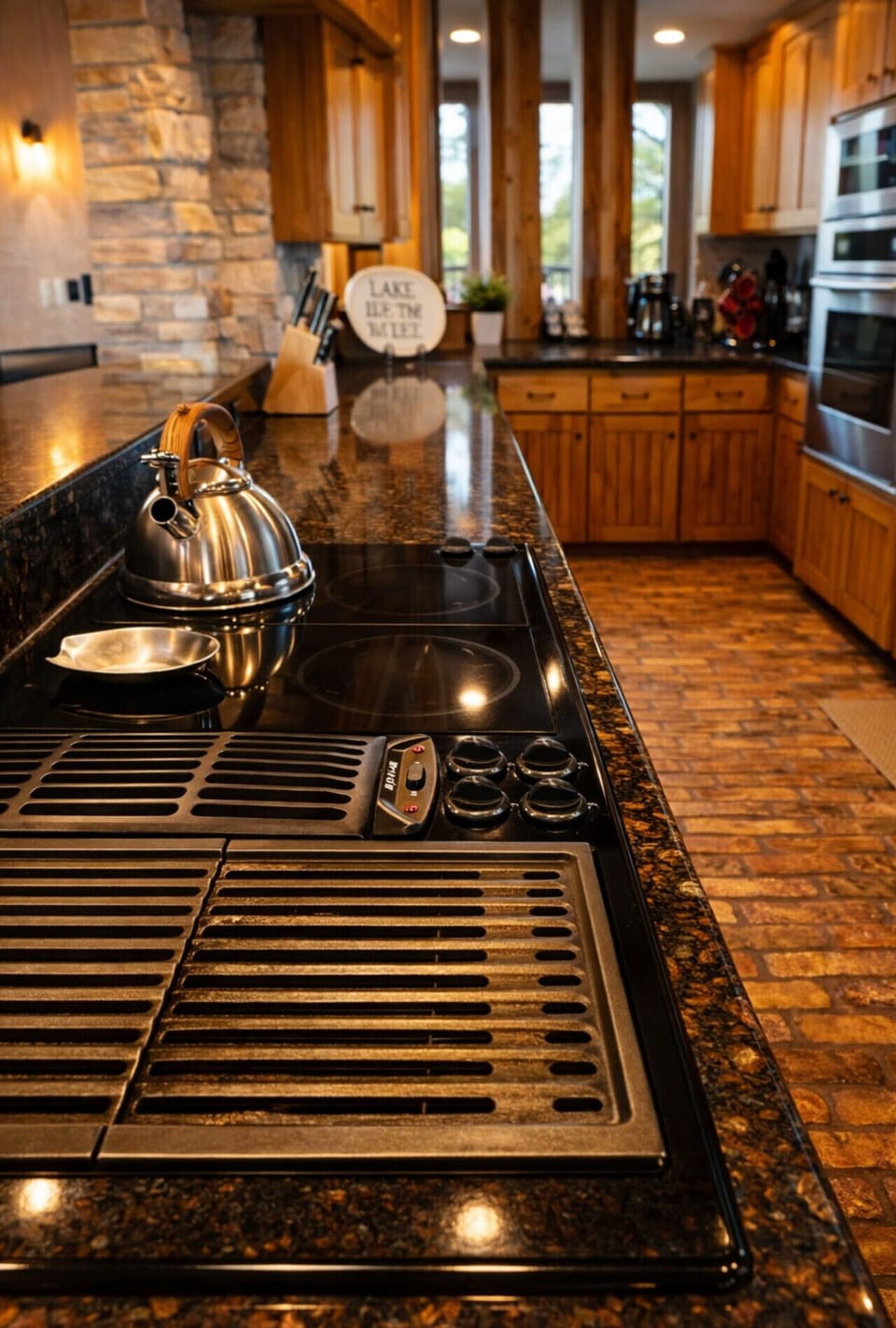 Rustic gourmet kitchen with granite countertops, modern cooktop, double ovens, and scenic window views — perfect for cooking and entertaining on your cabin getaway.
