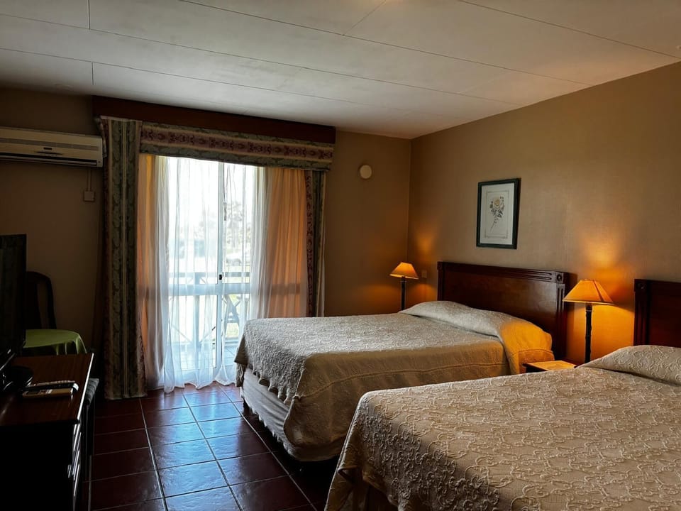 Standard Quadruple Room, Garden View | Minibar, in-room safe, blackout drapes, soundproofing