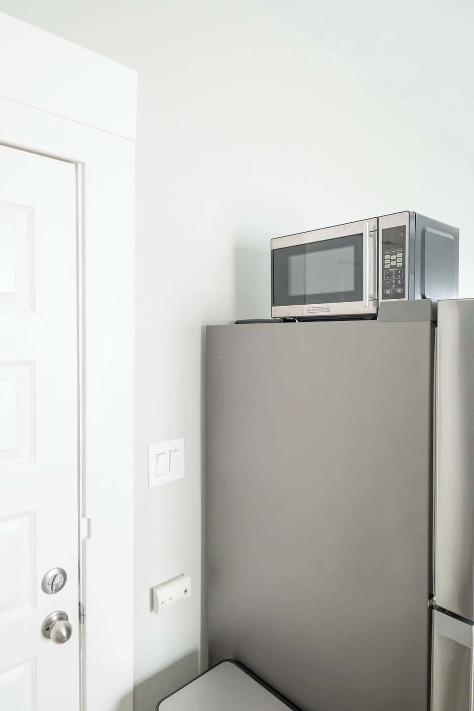 The microwave is located above the fridge/freezer