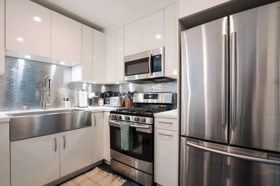 The kitchen features a modern stainless steel splashback and deep double sink