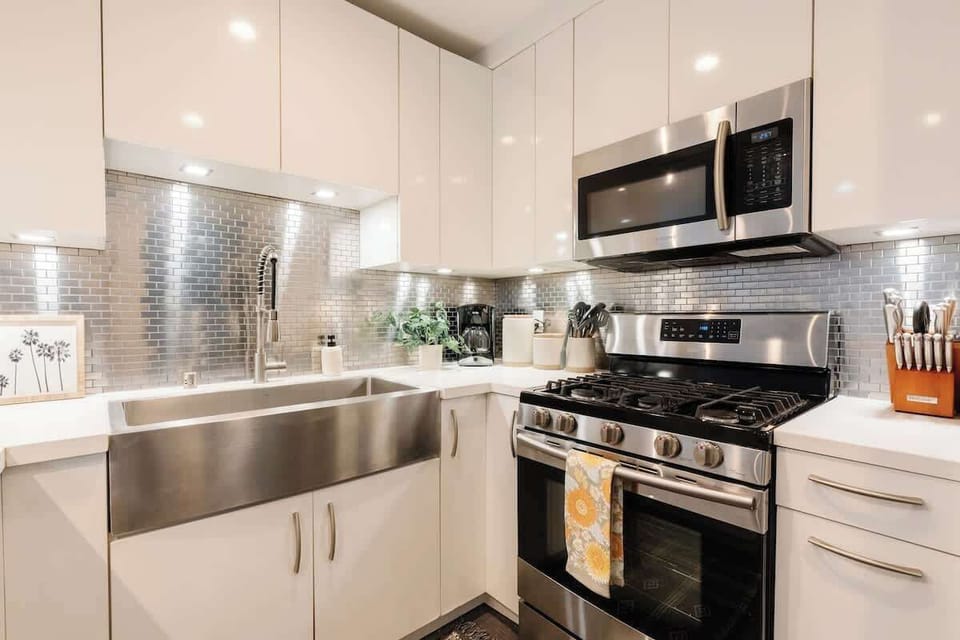 The kitchen features a modern stainless steel splashback and deep double sink