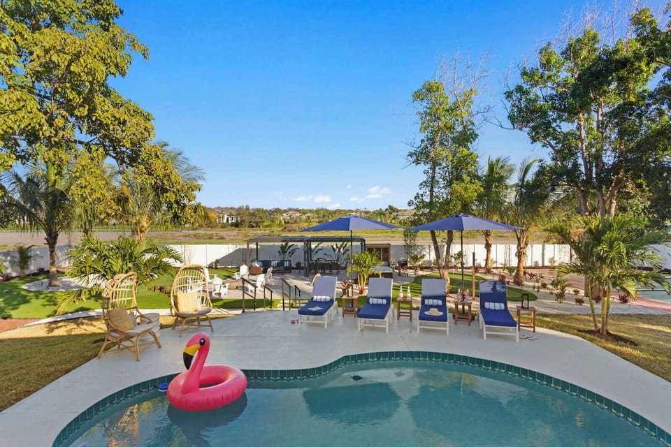 Backyard Oasis: Dive into relaxation with a pool, palm trees, and vibrant lounging areas!