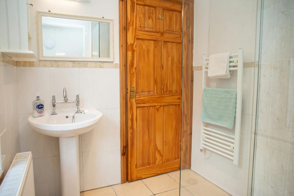 Towel rail with folded towels beside glass shower screen