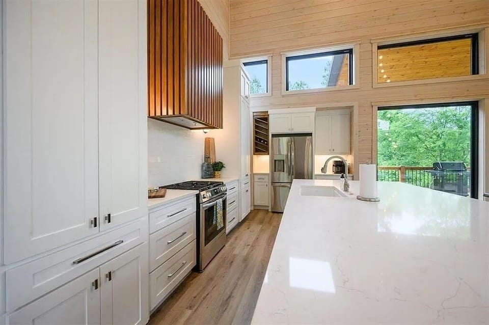 Chef's Paradise: Modern kitchen with sleek appliances and vibrant woodland views!
