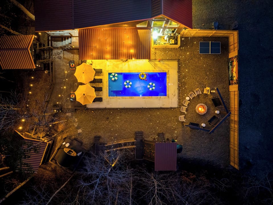 Outdoor Oasis: Dive into fun with a shimmering pool, cozy seating, and twinkling lights!