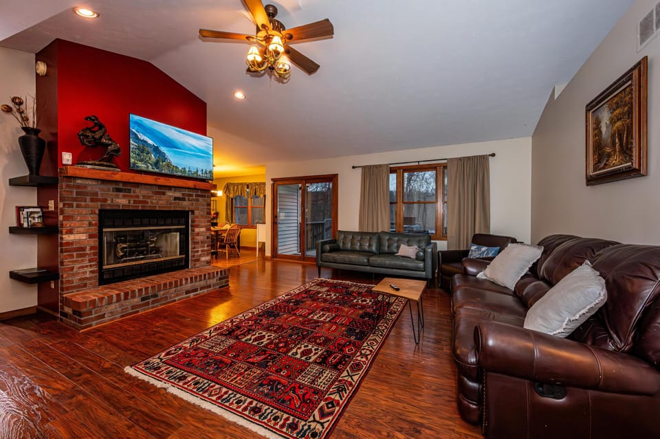 Cozy living room with stone fireplace and rich hardwood floors