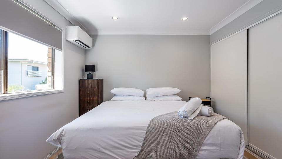 Comfortable bedroom with king bed, air-conditioning, and built-in wardrobe