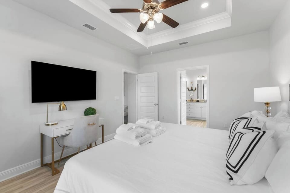 Bedroom 4: Enjoy comfort and style with a bright bedroom, cozy lamps, and a ceiling fan.
