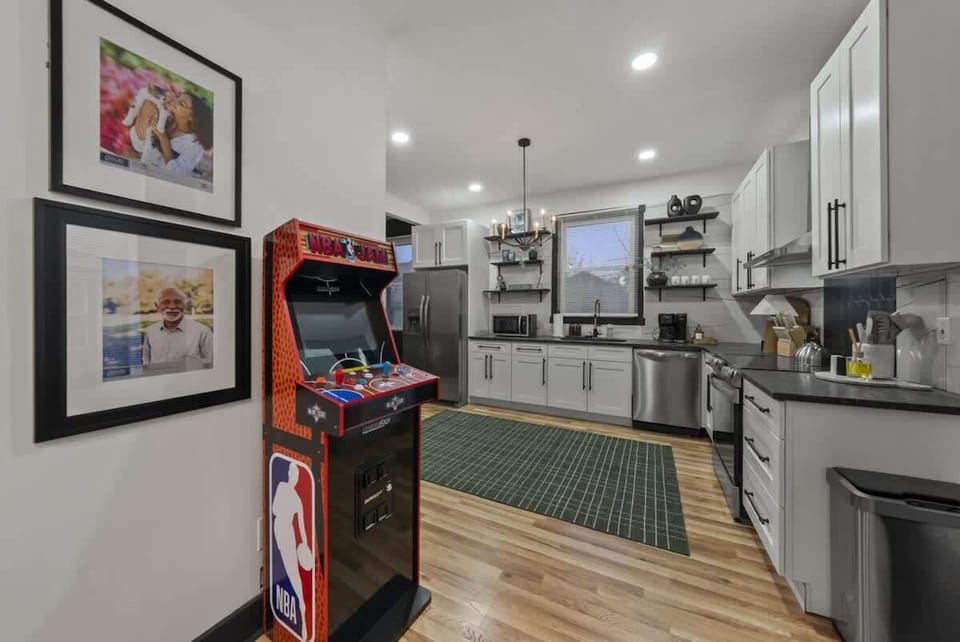 Fun game corner w/ arcade machine, art-lined walls & a playful setup perfect for friendly competition 