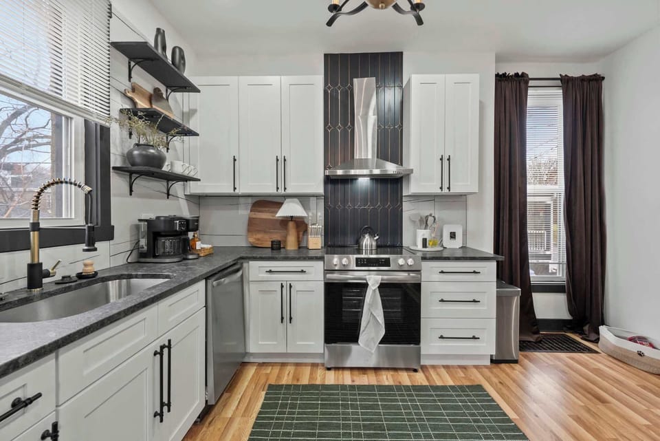 Stylish kitchen w/ long counters, open shelving & a central prep area