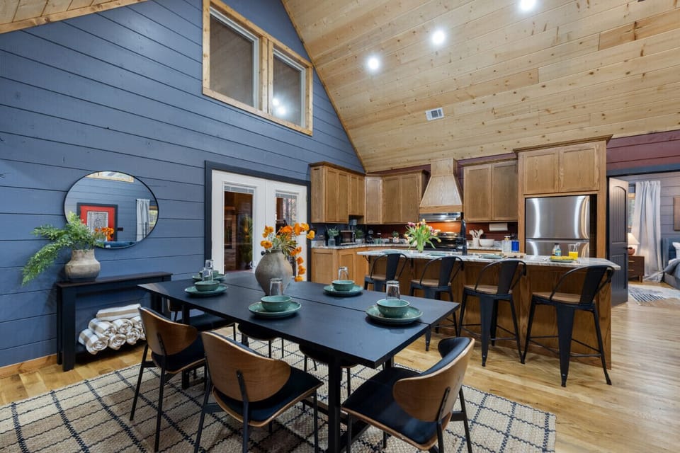 Cook, gather, and stay connected in your open kitchen + dining space—big island seating, warm wood ceilings, and room for the whole group to hang while meals come together. This is where the cabin feels like home.