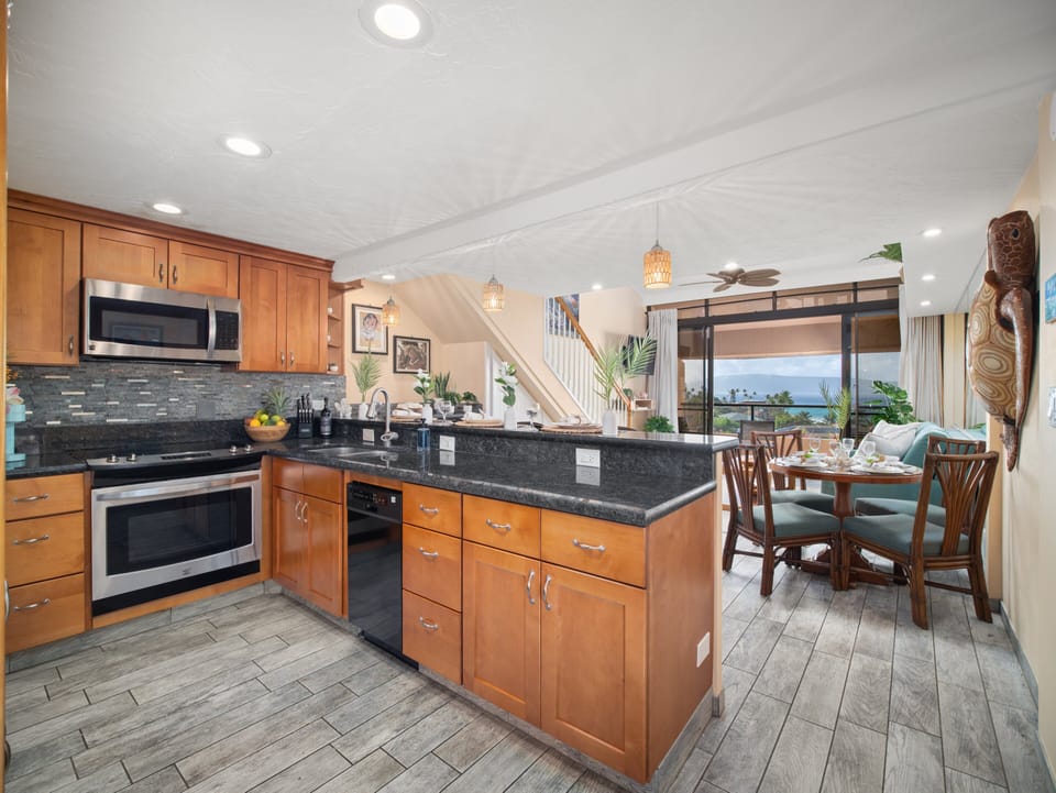 This open-concept kitchen and dining area offers a spacious layout ideal for entertaining, blending tropical design with modern Maui vacation comfort.
