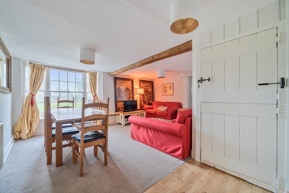 A comfortable living area with dining table, Smart TV, sofas and a coffee table for gathering indoors.