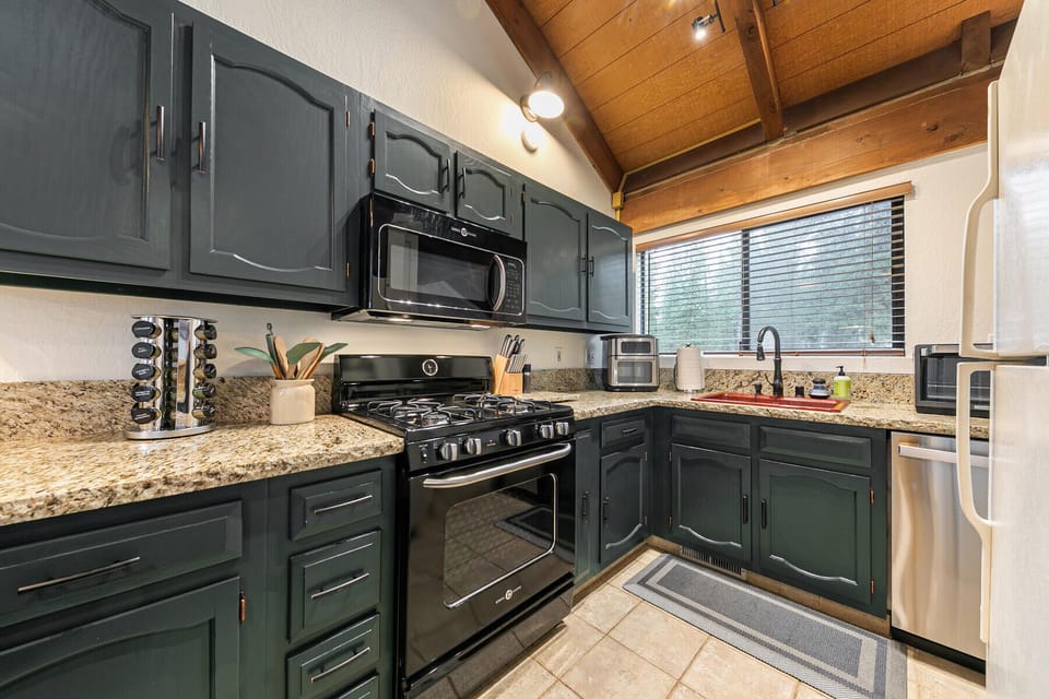 Renovated, fully equipped kitchen with warm finishes and modern appliances.