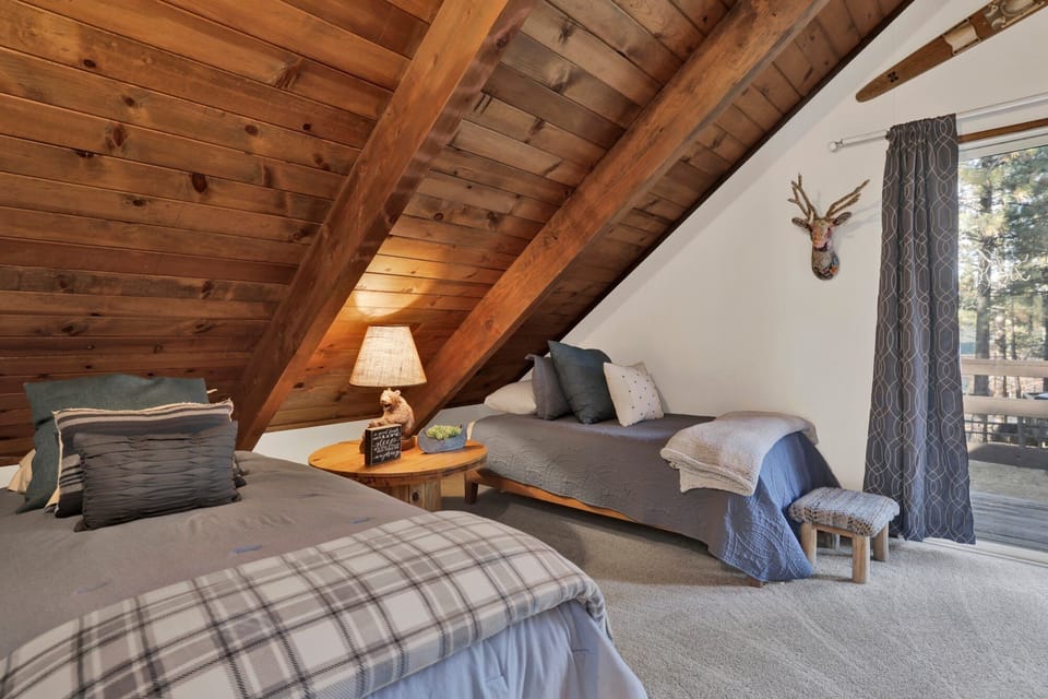 This spacious bedroom offers a queen-size bed along with two single beds, thoughtfully designed to provide comfort, flexibility, and a relaxing retreat after a day of mountain adventures.