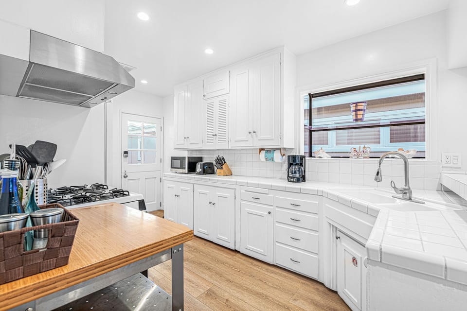 A white and bright kitchen offers a spacious, airy setting that blends coastal style with everyday functionality
                