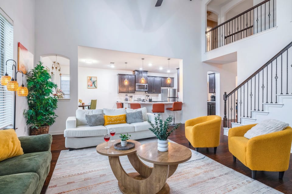 Bright open living room with soaring ceilings and stylish kitchen bar seating
