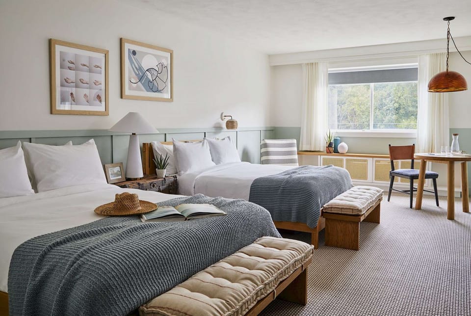 Spacious room with two beds, seating area, and large window