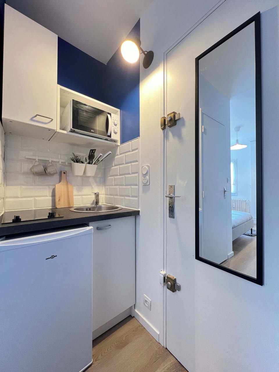 Kitchenette équipée — placards blancs, micro-ondes, évier et verrière dans le studio L'Azur Cartoucherie