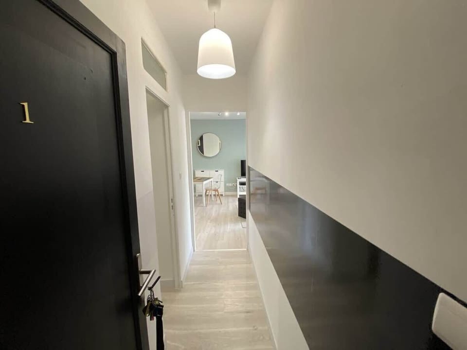 Entrée de l'appartement avec couloir vers les pièces de vie, soubassement élégant
