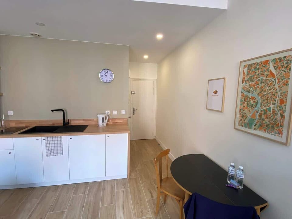 Vue d'ensemble cuisine et coin repas avec table pour deux personnes