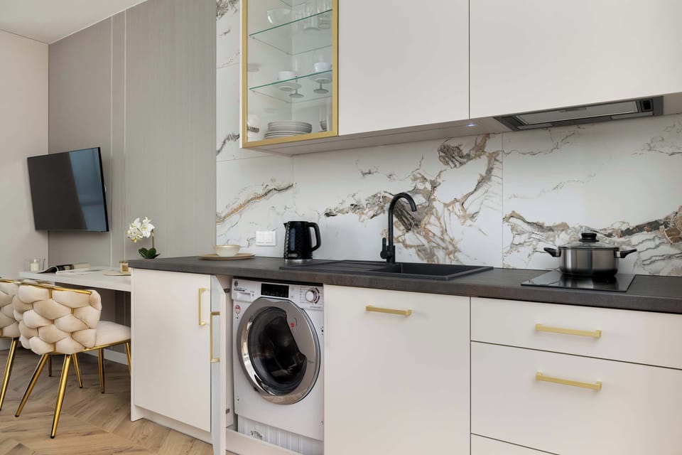 The contrast between light cabinetry and a marble-patterned countertop adds elegance while maintaining everyday functionality.