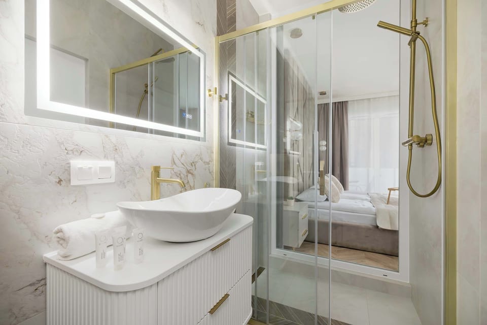 A thoughtful combination of light surfaces, glass, and gold accents gives the interior a fresh, hotel-style feel.