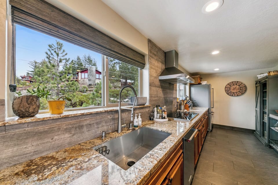 Your gourmet kitchen features granite counters, stainless appliances, and stunning forest views while you cook.