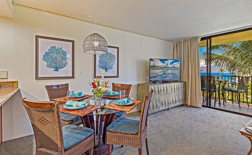 Bright, coastal dining with seating for four and tropical views right through the sliding glass doors.