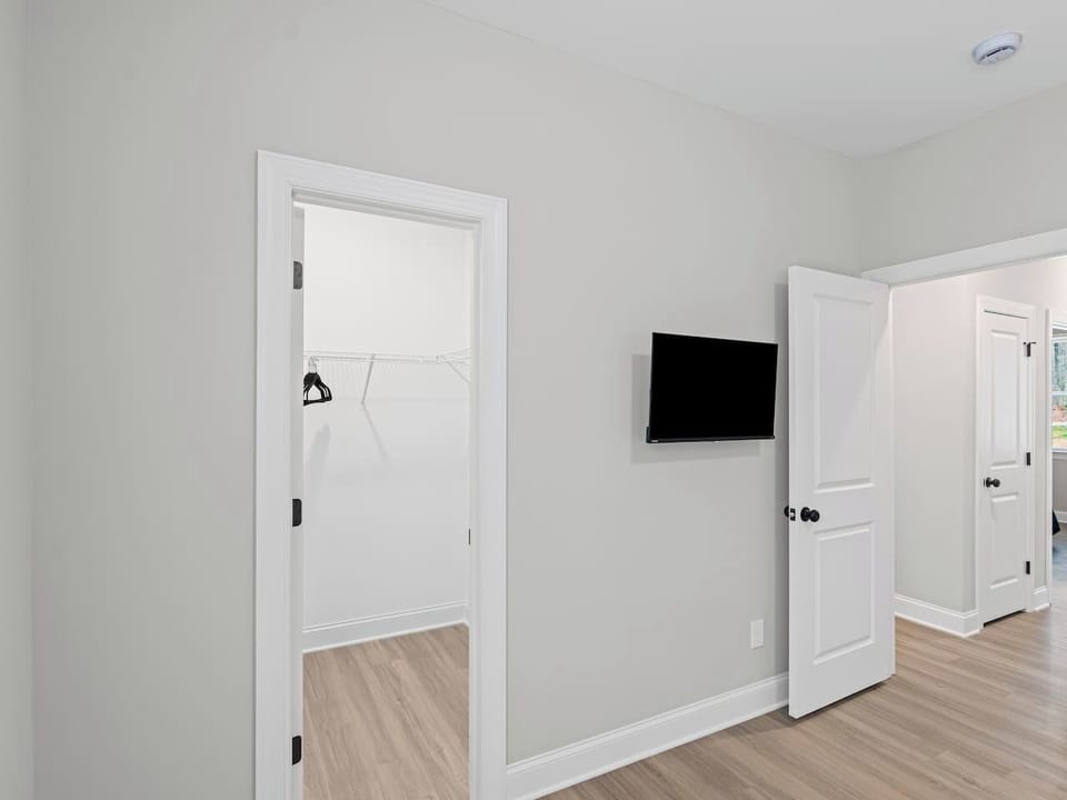 Primary suite features a walk-in closet and wall-mounted TV with streaming services for easy downtime and convenience.