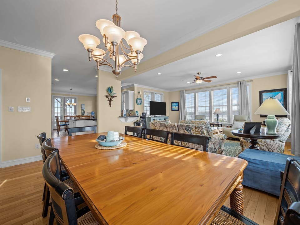 Gather around this beautiful wood table where sunlight streams through creating perfect moments for meals and conversation in your coastal retreat.