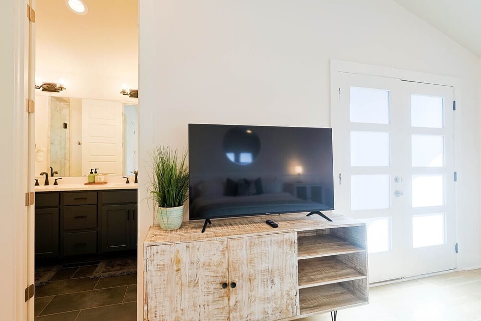 Sleek wall-mounted smart TV positioned next to bright patio doors.