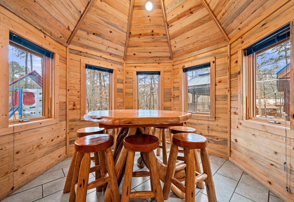 Framed by windows, the dining area feels bright and inviting while still offering peaceful views of the surrounding trees.
