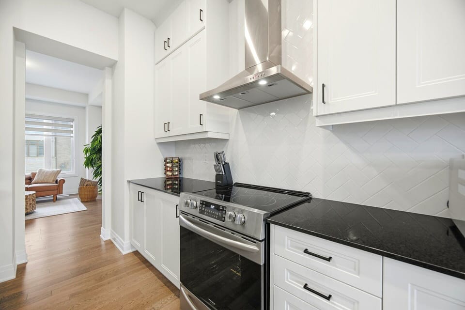 High-end cooking setup. Sleek stove and modern hood fan.